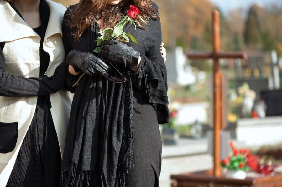 Kobieta w czerni z różą na cmentarzu